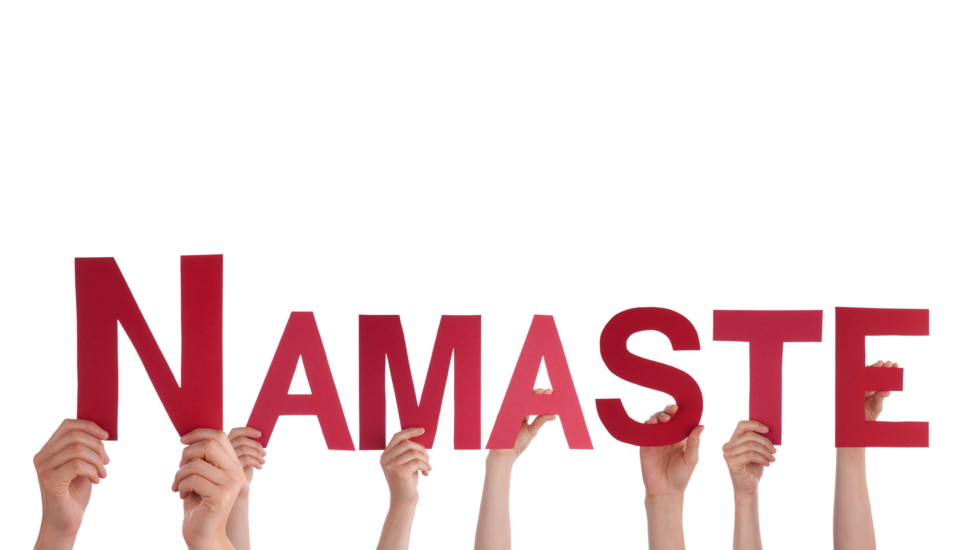 Hands of several people holding cut out letters for the word Namaste (in red)